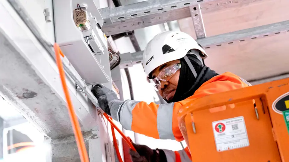 Mand I Arbejde Med Metroselskabet, Hjelm På Og Briller Står Ved Installator